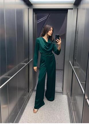 Комбінезон зі струмуючим коміром та довгими рукавами.  бічні складки на талії.  широкі штанини.