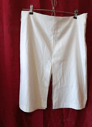 Белая юбка с разрезами спереди и сзади.