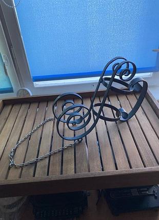 Подставка для бутылки с ручкой, в виде кареты, выполненная из кованого металла.