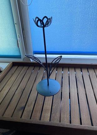 Подсвечник в форме цветка выполненный из металла.