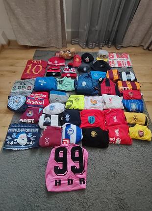 Футбольная атрибутика, футболка, кепки, шапки, куртки, игрушки.