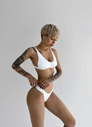 Топ купальний на застібці, білий  та трусики класичної форми з декоративними резинками по боках