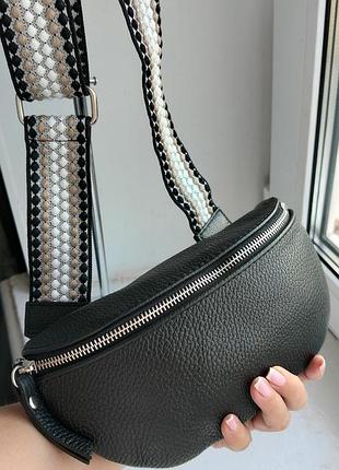 Новая кожаная сумочка на широком ремешке.