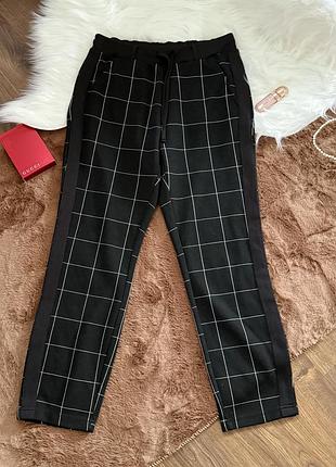 Штани у клітинку чорного кольору
