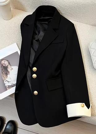 Стильний чорний піджак з білими манжетами та золотою фурнітурою