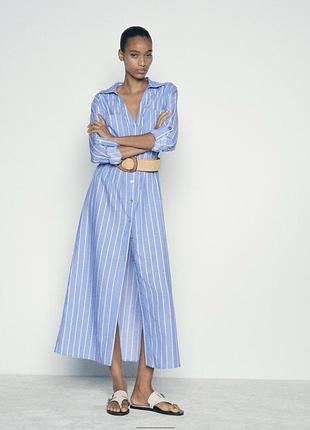 Сукня міді з коміром та рукавами з відворотами, хлястиками та гудзиками.