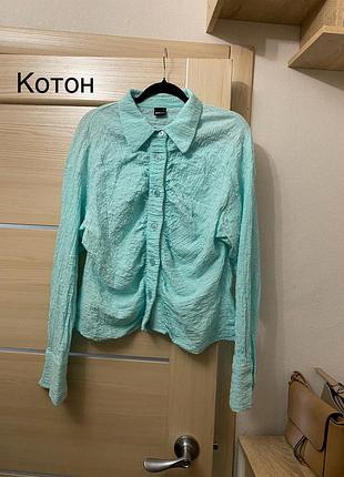 Бірюзова натуральна блуза з цікавою жатою текстурою, жатою тканиною яскраво блакитного кольору по фігурі на ґудзиках