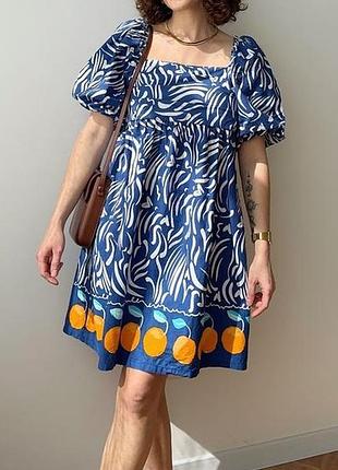 Хіт сезону синьо-біле плаття з помаранчевими фруктами по низу.