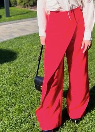 Стильні червоні штани-палаццо з асиметричною накидкою спереду