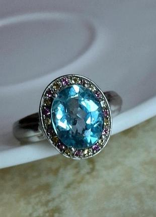 Каблочка с голубым топащом и сапфирами желтого и фиолетового цвета