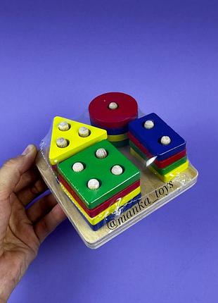 Деревʼяний сортер з геометричними фігурами.