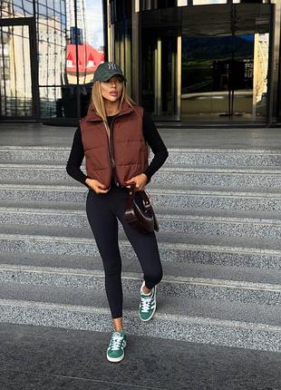 Коротка осіння пухова жилетка жилет із затяжками по низу