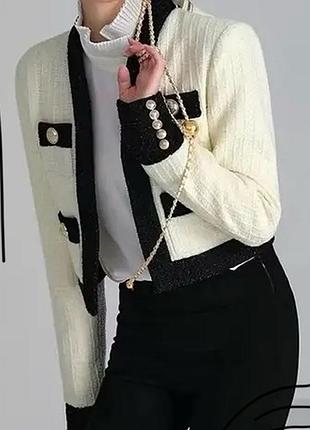 Стильний білий з чорний твідовий піджак з золотими ґудзиками та чорними манжетами