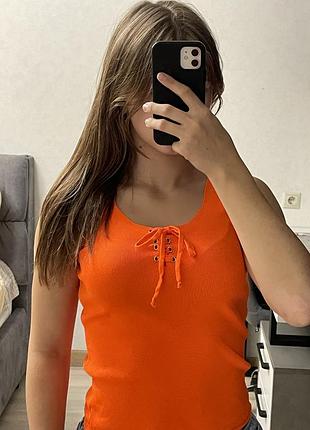 .	яскравий помаранчевий топ на зав’язках