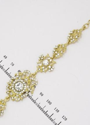 Браслет no 332 ажурний із білими стразами на основі під золото.