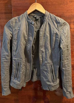 Легка жіноча куртка, має дві кишені на блискавці спереду, а також декоративні елементи на плечах та рукавах.