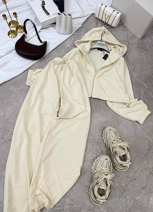 Практичный женский костюм с укороченной кофтой с капюшоном на молнии и свободных штанов палаццо