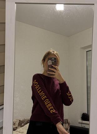 Кофта бордового кольору с написом на рукавах
