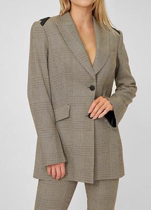 Діловий стильний костюм з цікавими елементами крою у клітинку