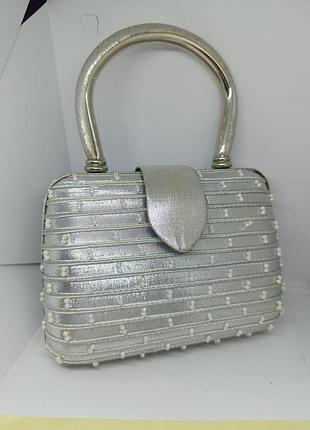 Серебристая каркасная сумочка.