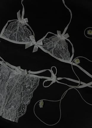Білий мереживний комплект із бантиками, бюстгальтер на зав’язках, трусики з відкритим доступом.
