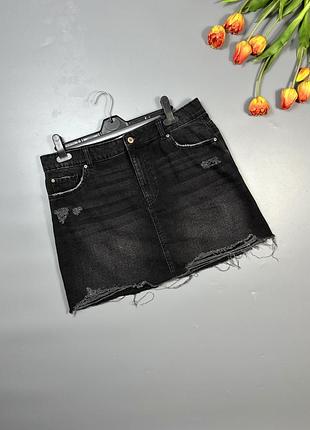 Чорна джинсова спідниця з рваним краєм та потертостями