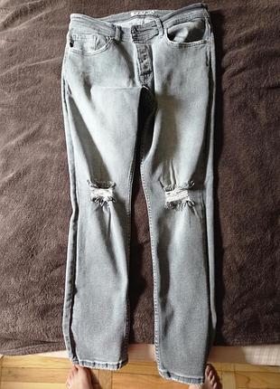 Джинсы серые с потертостями на коленях