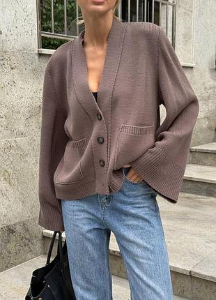 Кардиган имеет свободный крой и выполнен из плотной трикотажной ткани