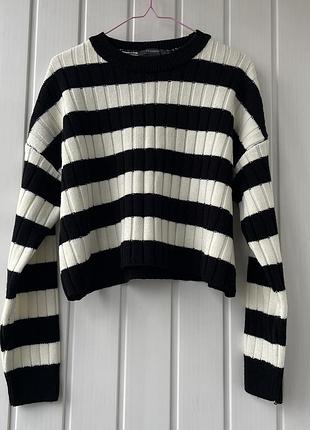 Жіночий вʼязаний джемпер в чорно-білу смужку.