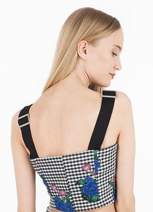Вкорочений топ із принтом у клітинку та квітковою вишивкою.