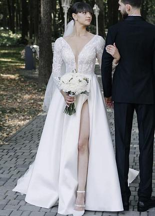 Весільна сукня кольору айворі з довгим рукавом, розрізом та шлейфом