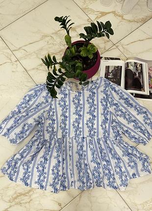 Жіноча ніжна біло-блакитна приталена блуза з геометричним і квітковим принтом та завʼязками на спинці