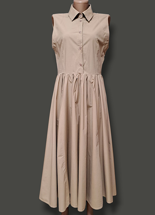 Бежевое платье-рубашка без рукавов с расклешенной юбкой.