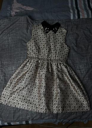 Золота сукня-трапеція з чорним коміром, прикрашеним паєтками