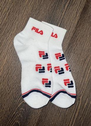 Білі шкарпетки fila з червоно-синім логотипом.