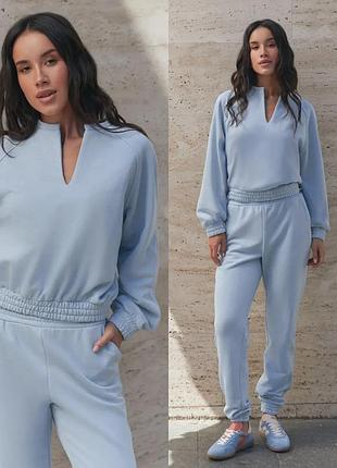 Свободный костюм из трехнитки с брюками и свитшотом на резинке голубого цвета