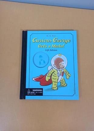 Книга "curious george gets a medal" ("допитливий джордж отримує медаль"), написана та проілюстрована г. а. реєм та маргрет рей.