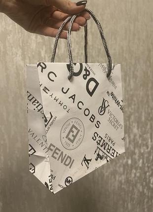 Маленький білий подарунковий пакет з догптипами брендів