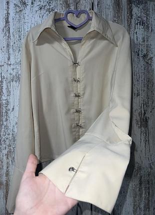 Бежева сорочка з металевими застібками-гакками