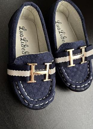 Це дитячі сині замшеві лофери з пряжкою у вигляді літери "h". 22 розмір
