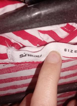 Это красно-белая полосатая блузка с высоким воротником.