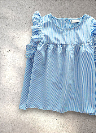 Голубая блузка в тонкую полоску с рюшами на плечах