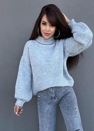 Теплий в'язаний светр вільного крою з горловиною-хомутом з об'ємними рукавами на манжетах
