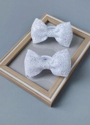 Бантики для дівчаток у різних кольорах, блискучі святкові аксесуари.
