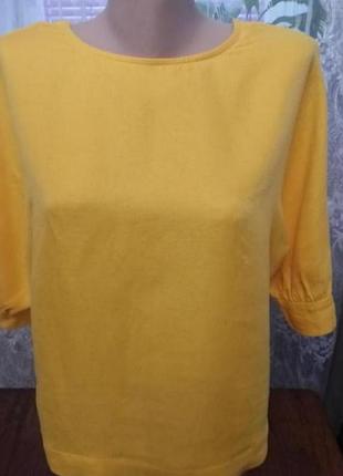 Блузка ярко-желтого цвета с открытой спиной.