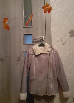 Дубленка короткая, имеет меховую отложку, по бокам карманы, тепла. серого цвета, на худи девочку на рост 145/150.