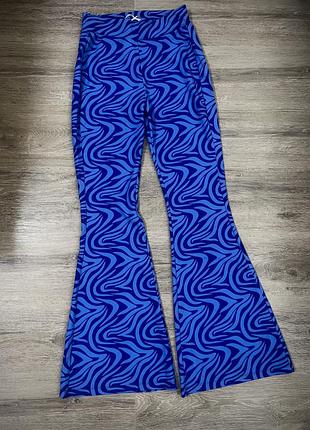 Яскраві розкльошені штани з абстрактним принтом