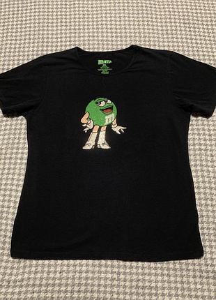 Чорна жіноча футболка m&m's із зеленою цукеркою-персонажем із блискіток.