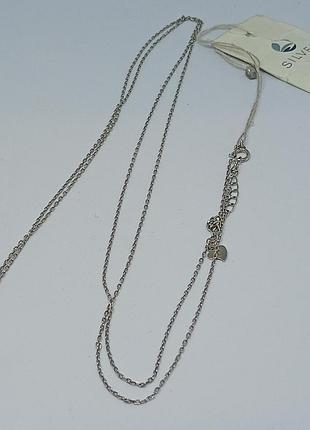 Длинная серебряная цепочка с подвеской.