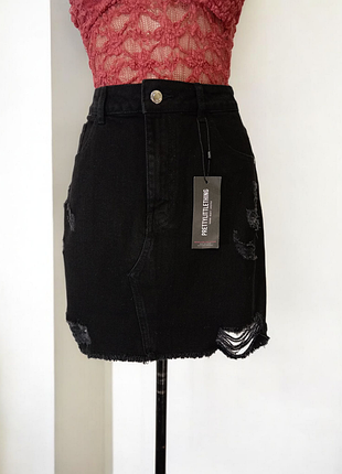Джинсовая юбка рваная.